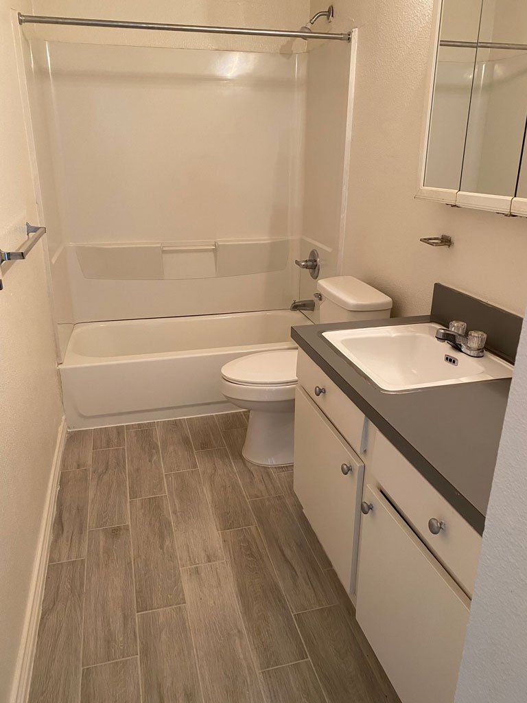A bathroom with a toilet , sink and bathtub.