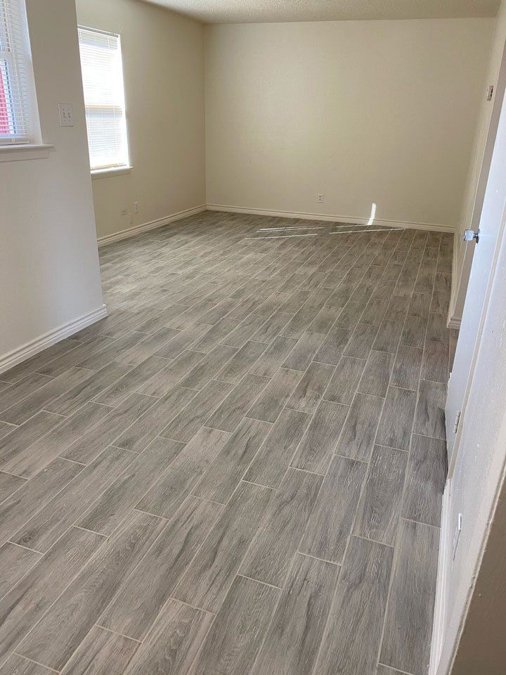A living room with a wooden floor and a window.