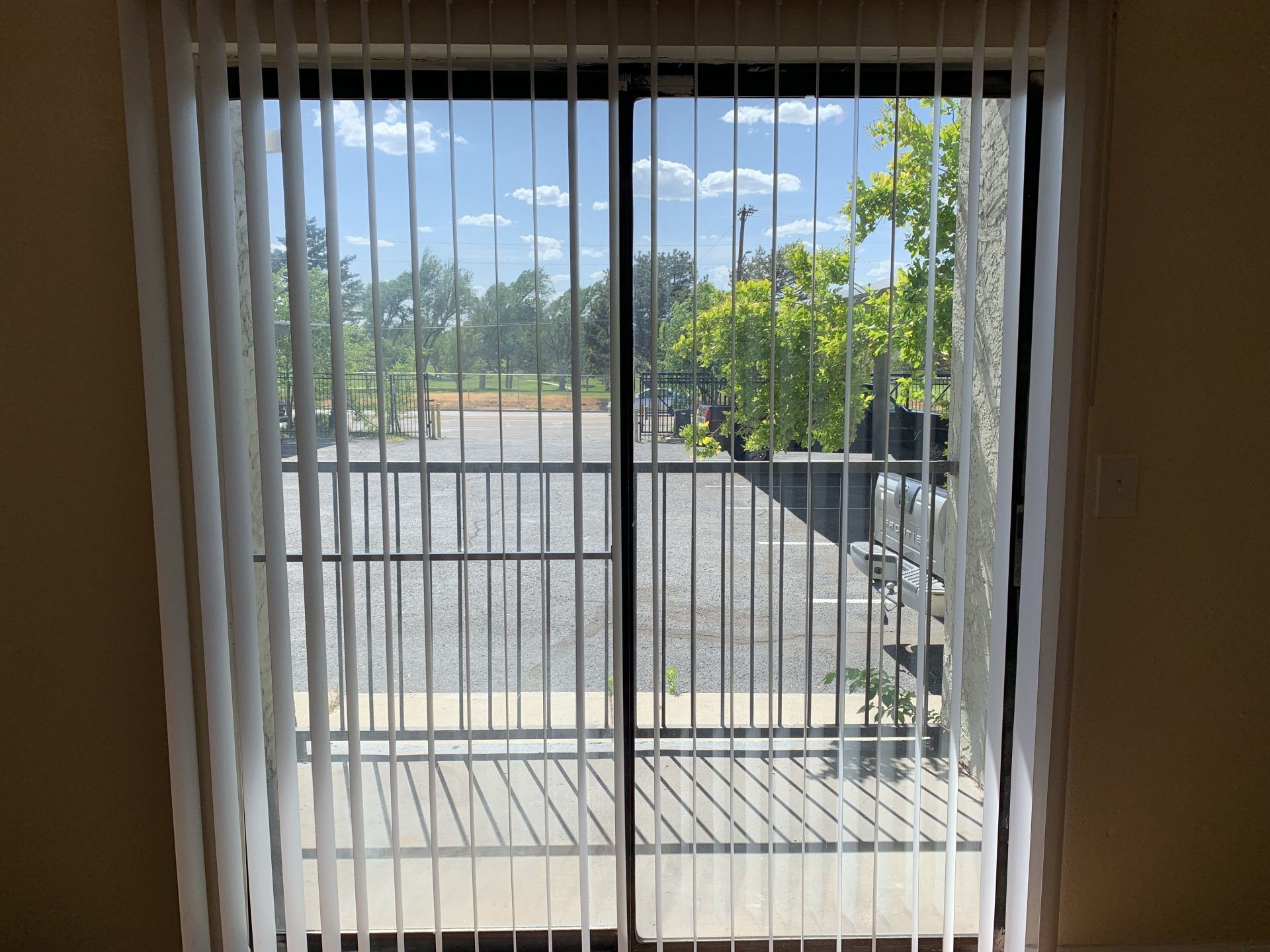image of folding blinds and sliding glass door looking outside at Bel-Aire/Fairway Apartments in Amarillo, TX