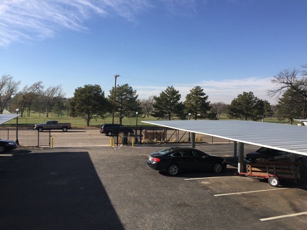 A parking lot with cars parked under a canopy.