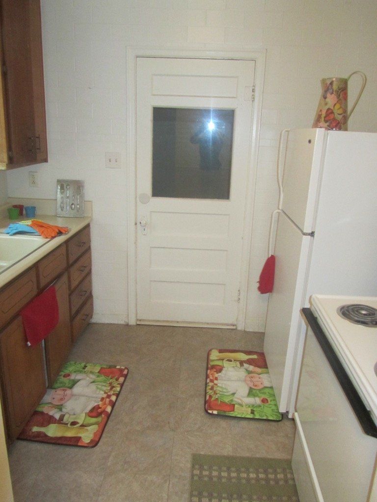 A kitchen with a white refrigerator and a window