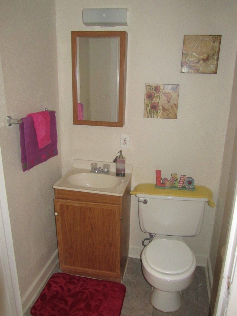 A bathroom with a toilet , sink and mirror