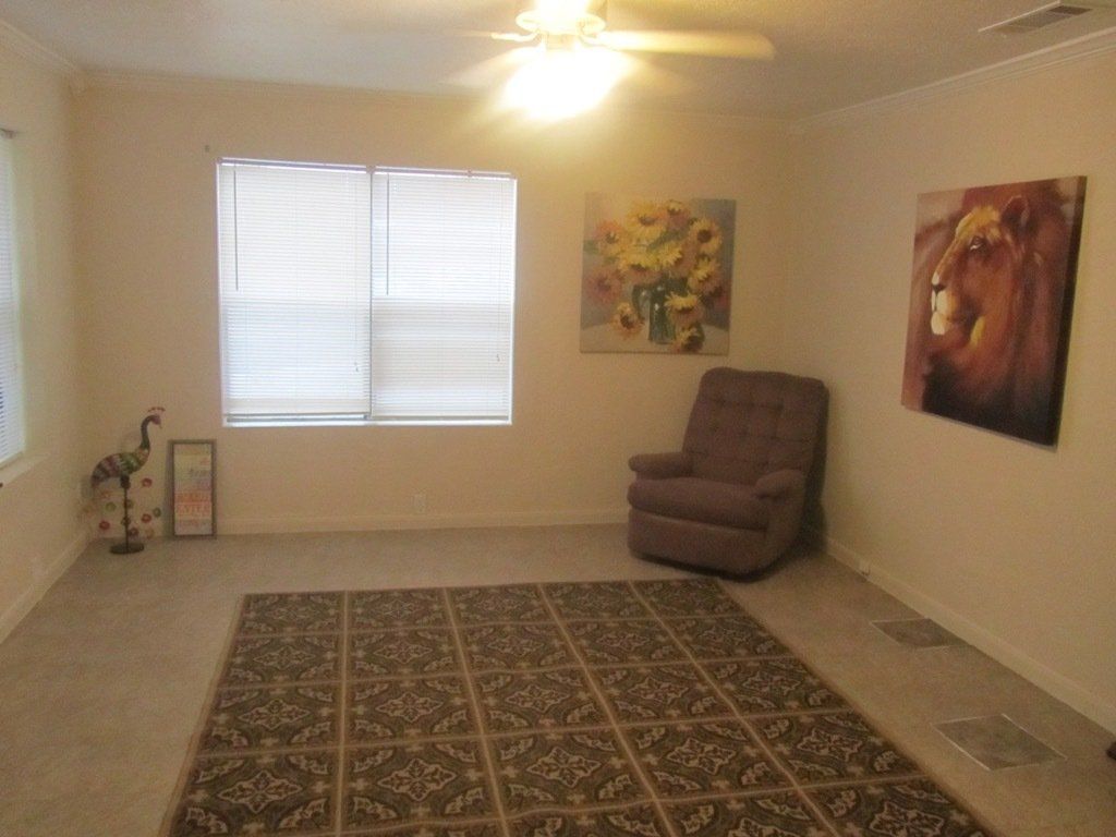 A living room with a chair and a painting on the wall