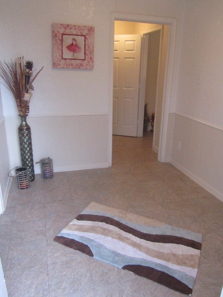 A hallway with a rug and a picture on the wall