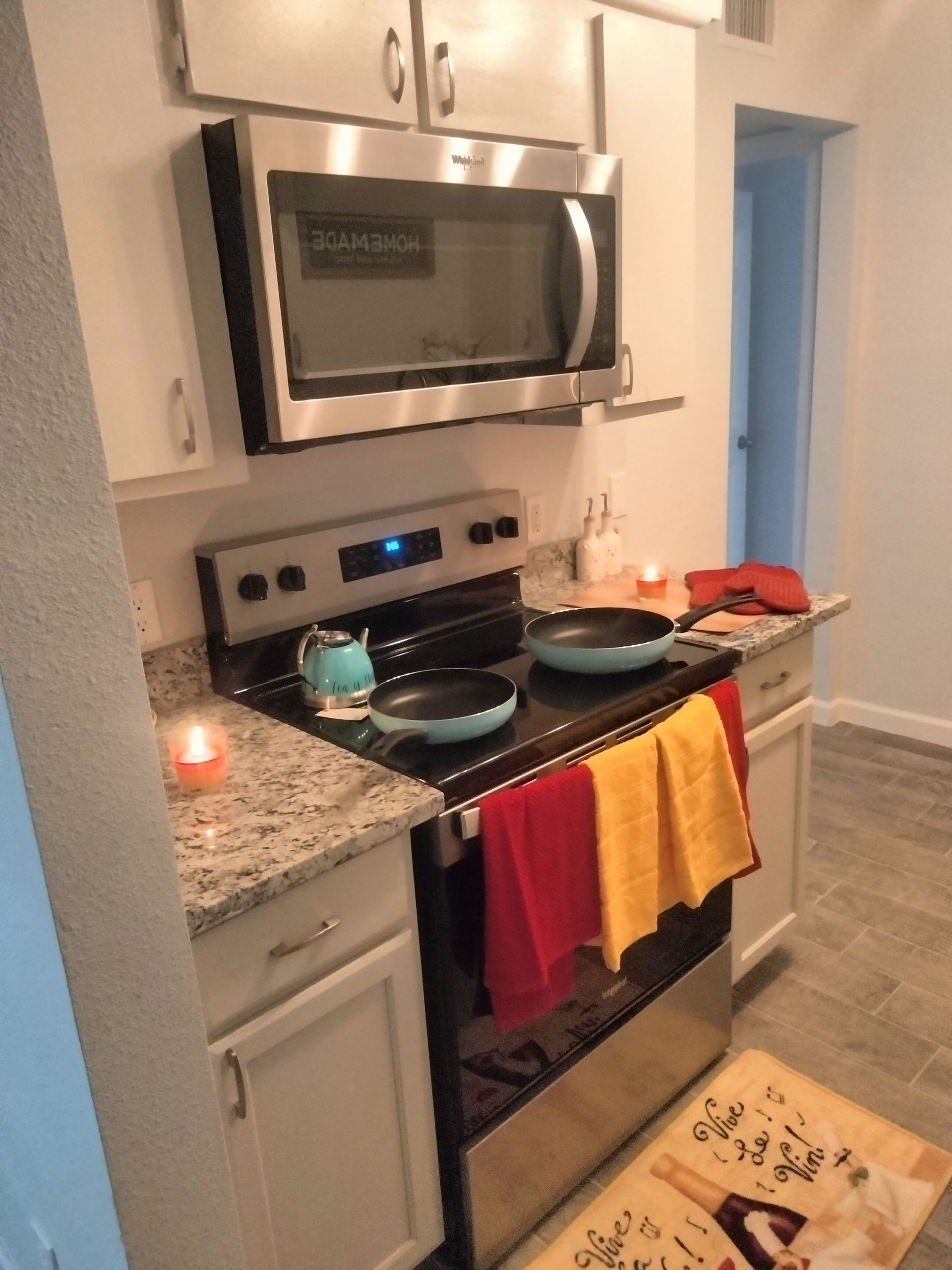 kitchen of Luxury upgraded 2 bedroom with tile flooring, stainless steel stove top oven, stainless steel microwave hood & granite countertop
