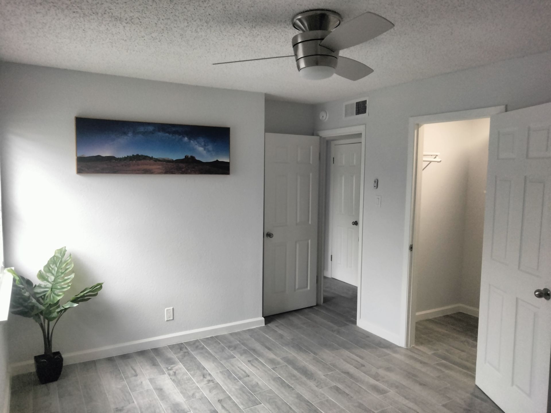A 2nd bedroom with ceramic tile flooring, a modern ceiling fan with light and a walk-in closet at Lions Court Apartments in Wichita Falls TX