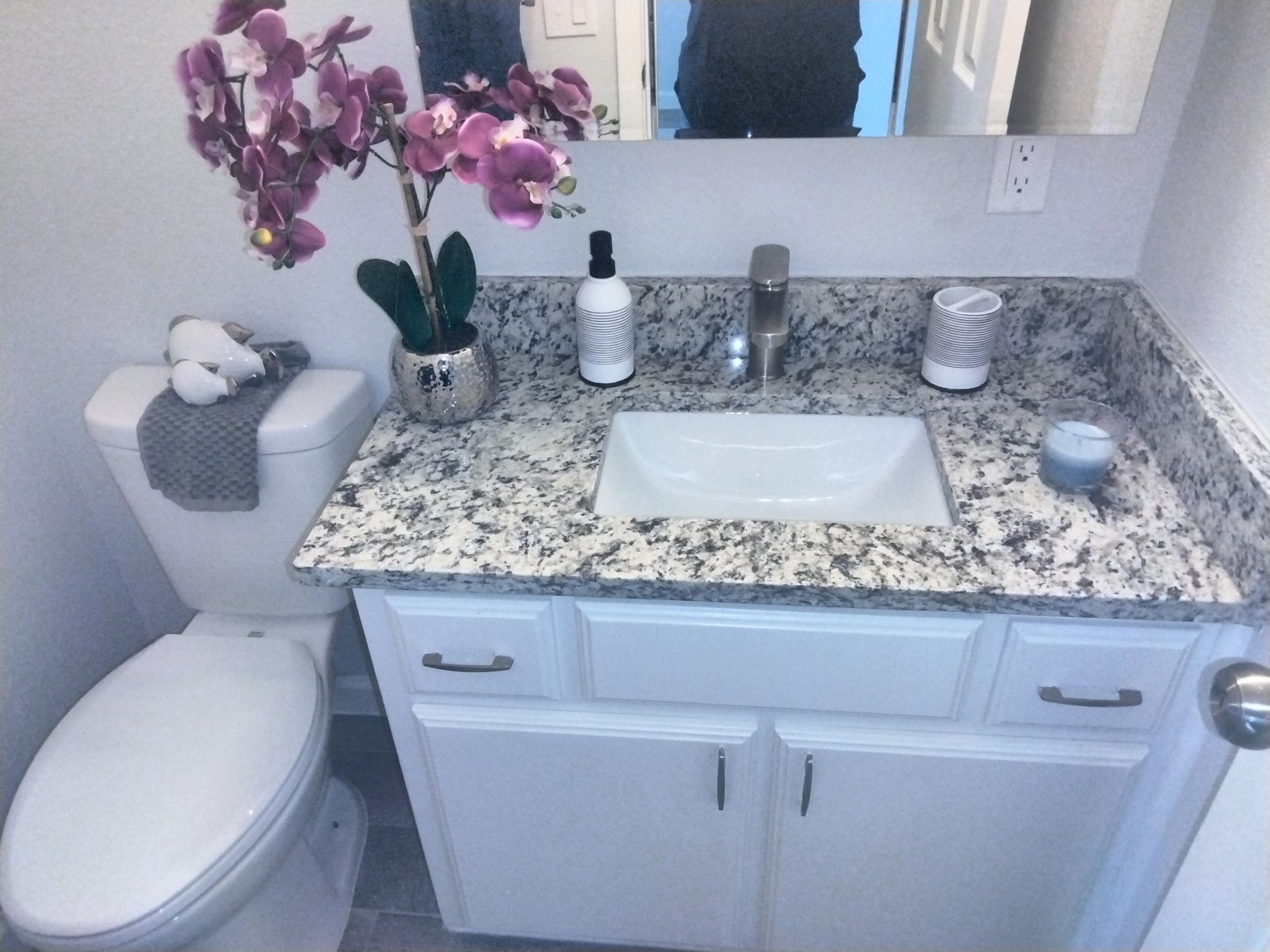 luxury upgraded bathroom with granite countertop sink,  a toilet , and mirrored medicine cabinet