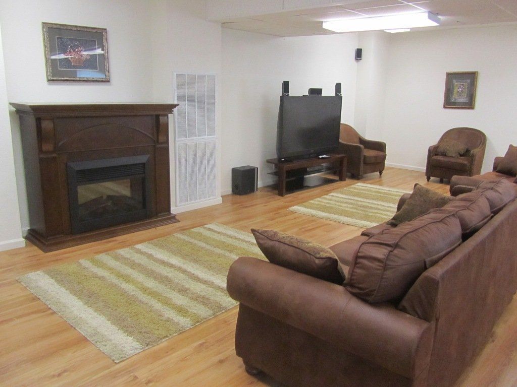 A living room with a brown couch and a fireplace