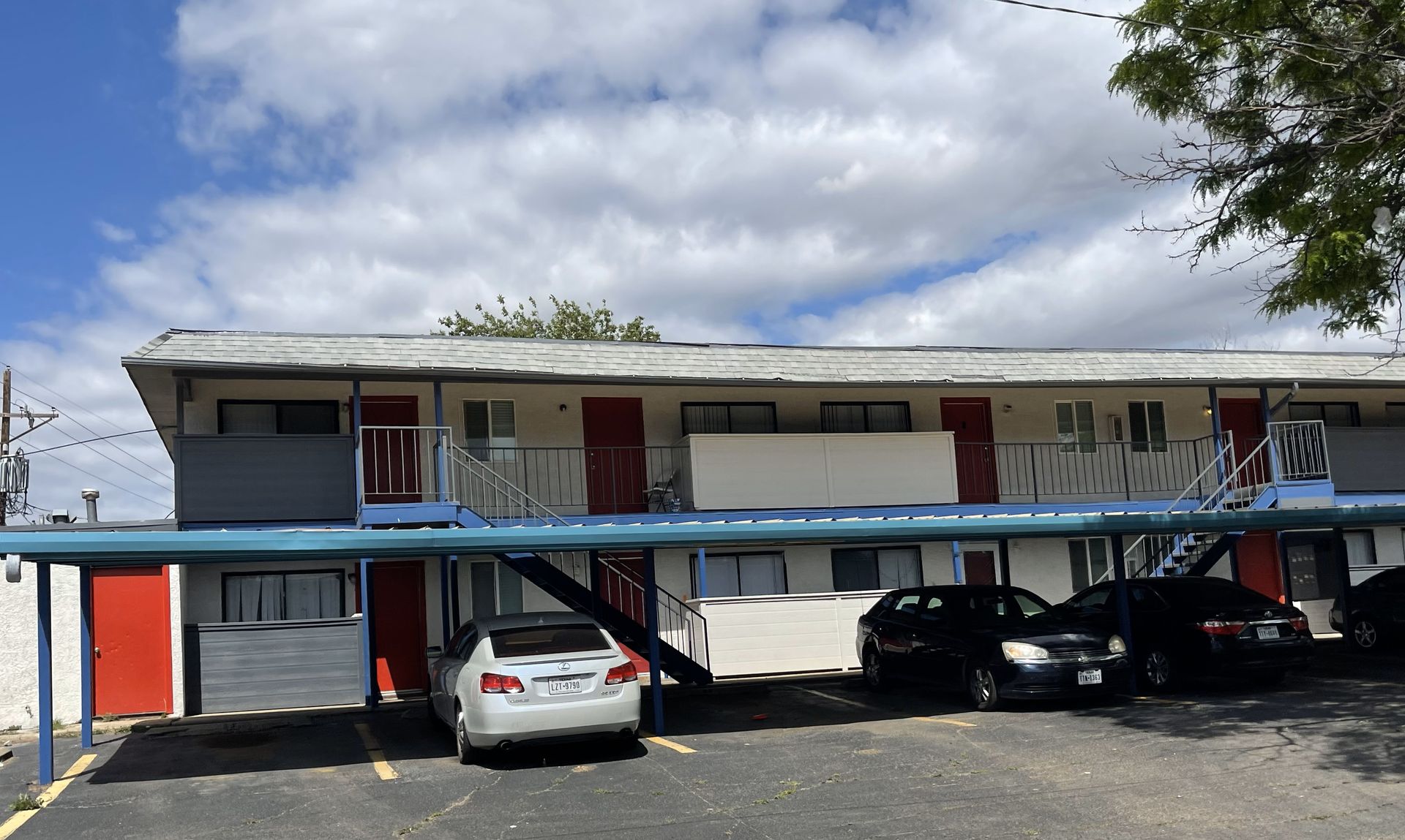 A white car is parked in front of a building