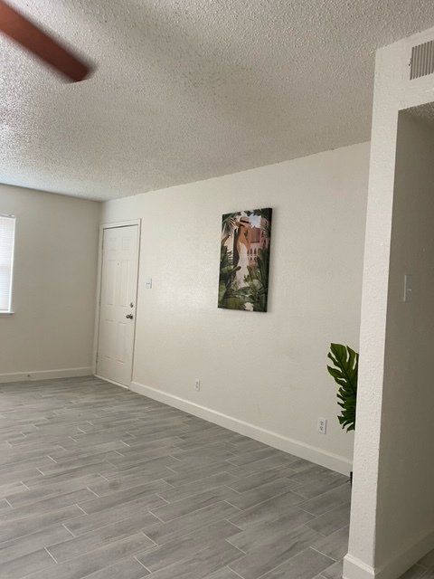 A living room with a painting on the wall and a ceiling fan