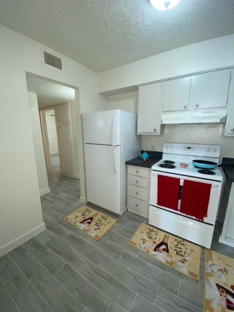 A kitchen with a stove top oven and a refrigerator