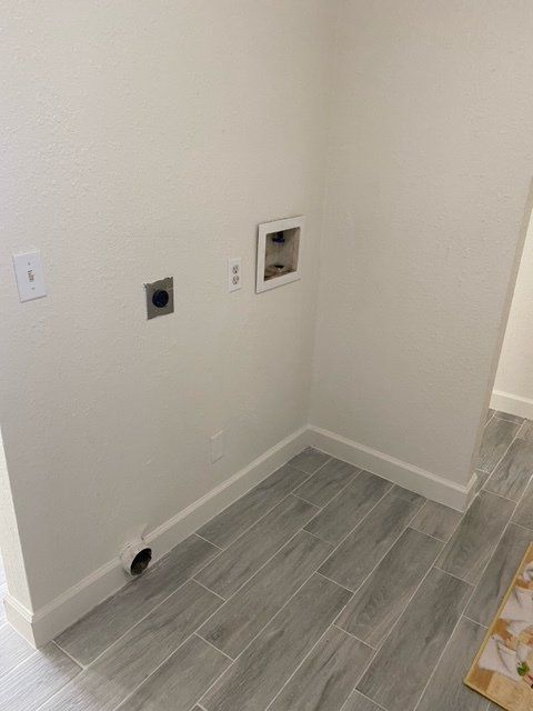 A laundry room with a gray tile floor and white walls.