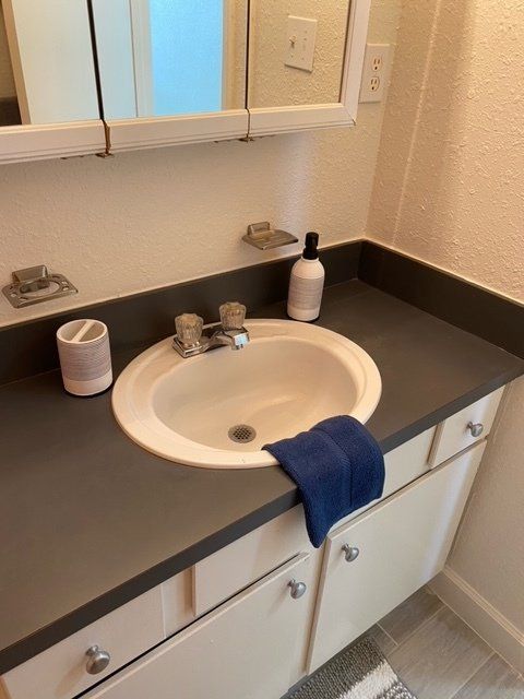 A bathroom sink with a blue towel on the counter
