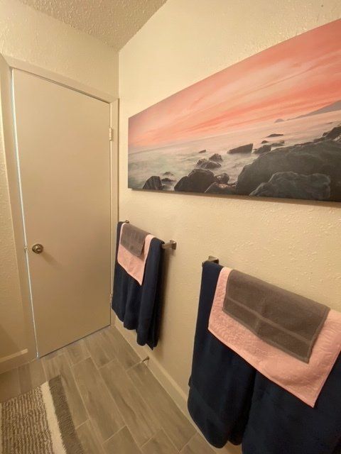 A bathroom with a painting on the wall above the towels
