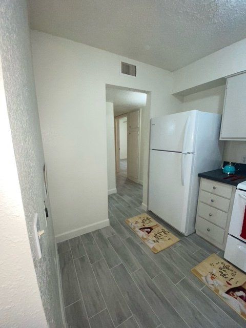 A kitchen with a white refrigerator and a stove
