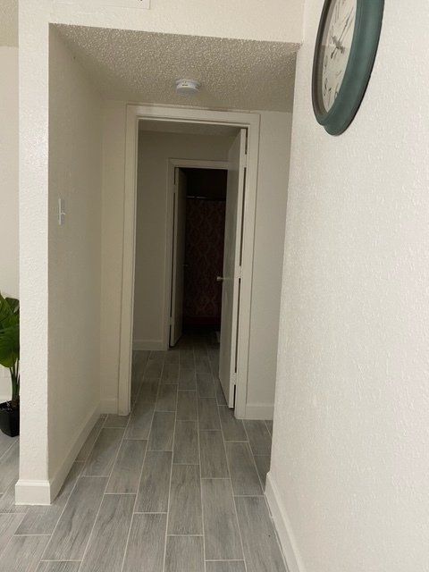 A hallway in a house with a clock on the wall.