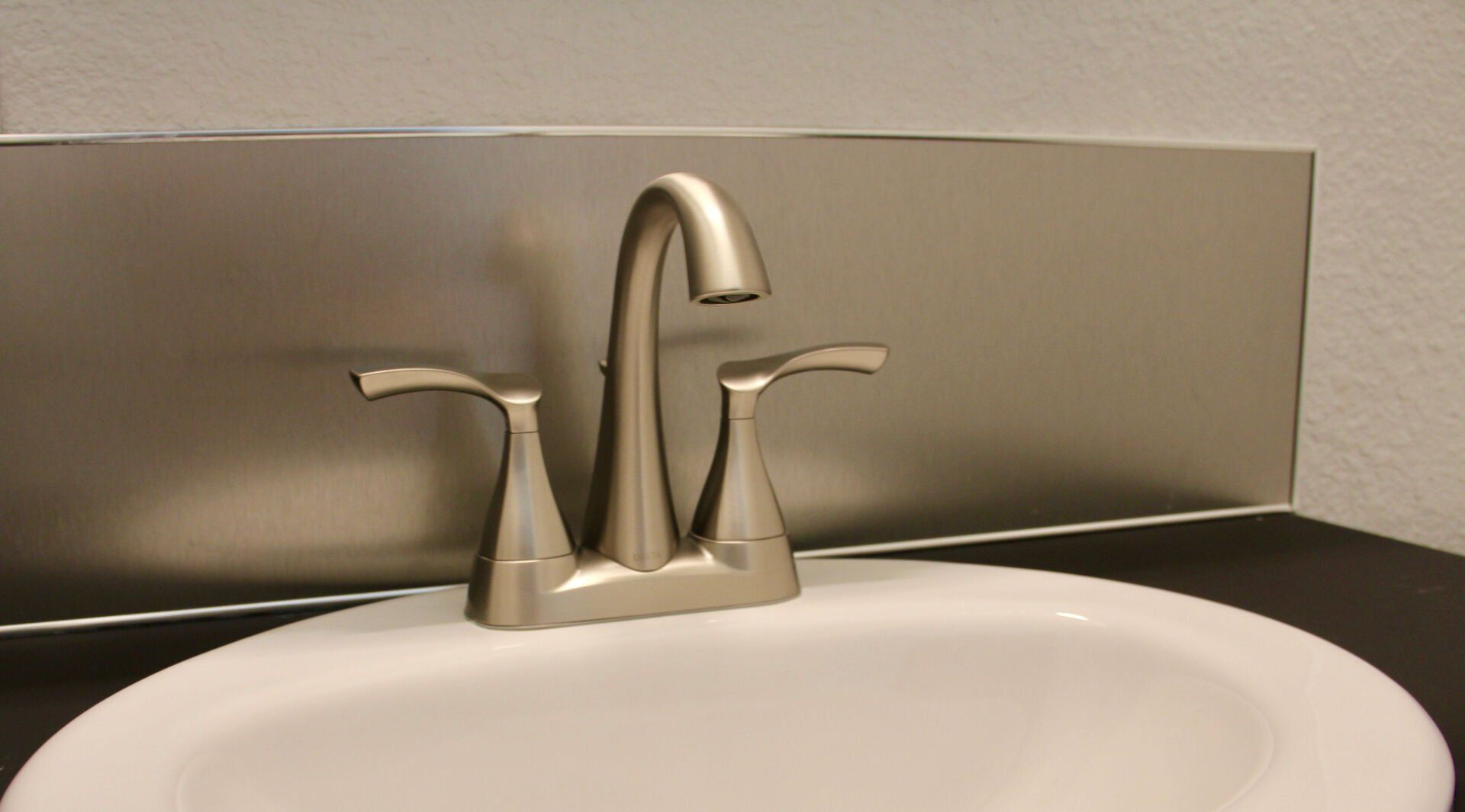 A bathroom sink with a faucet and a mirror