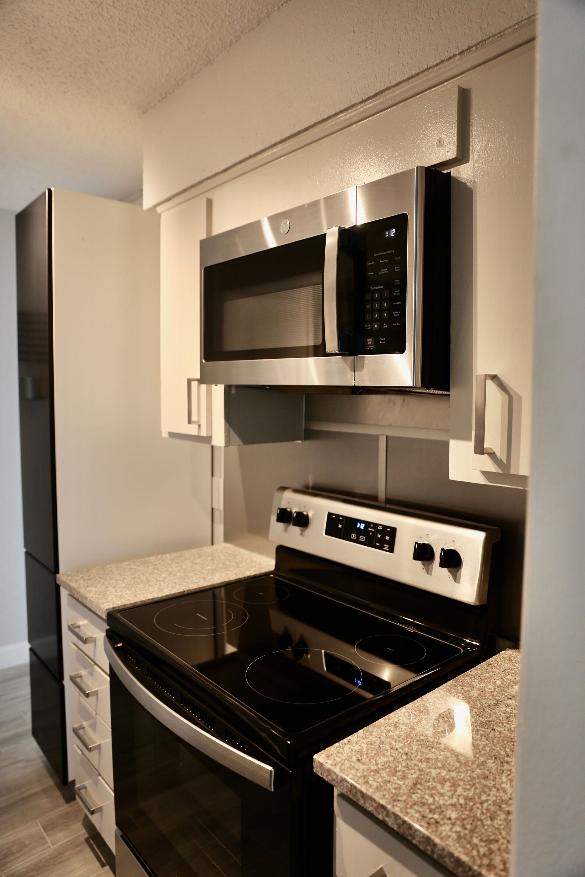 A kitchen with a stove , microwave and refrigerator