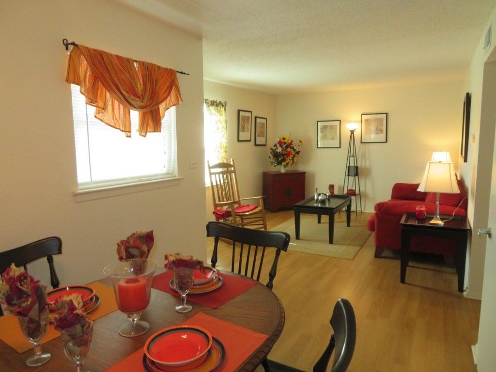 interior image living & dining area with hardwood floors, white walls, red accents at Lions Court Apartments