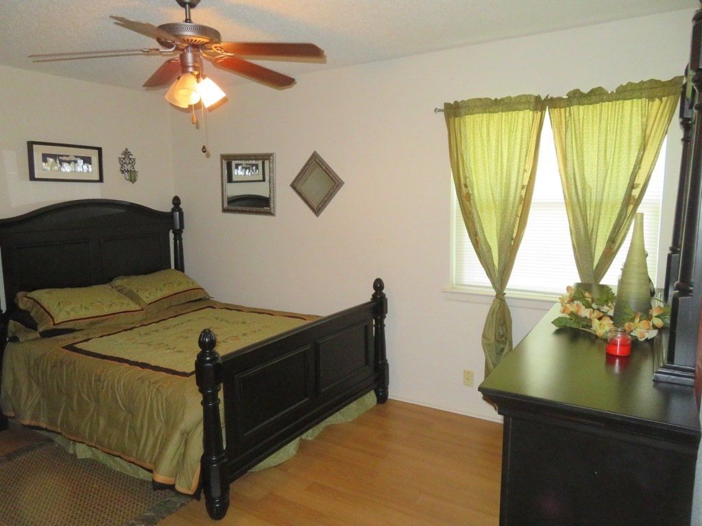 large master bedroom image with ceiling fan with light & green accents