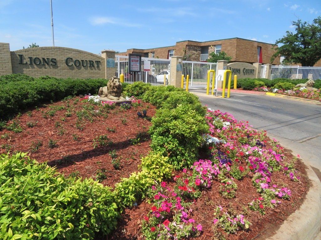 Image of flowerbed in front of the main entrance of Gated Apartments at Lions Court Apartments Wichita Falls TX