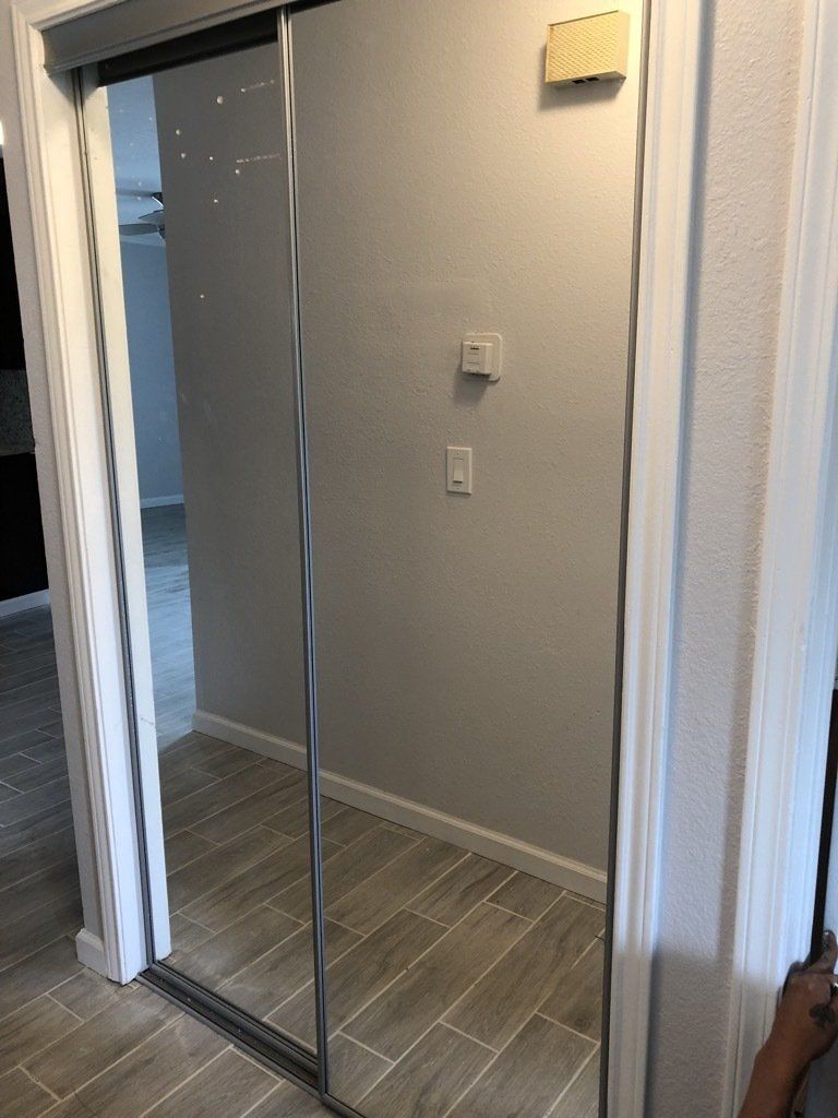 A person is standing in a hallway next to a sliding glass door.
