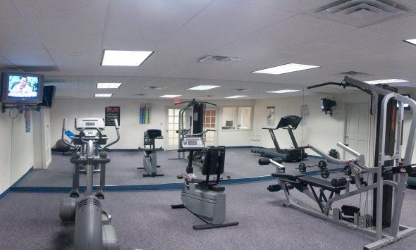 A gym with a tv hanging from the ceiling