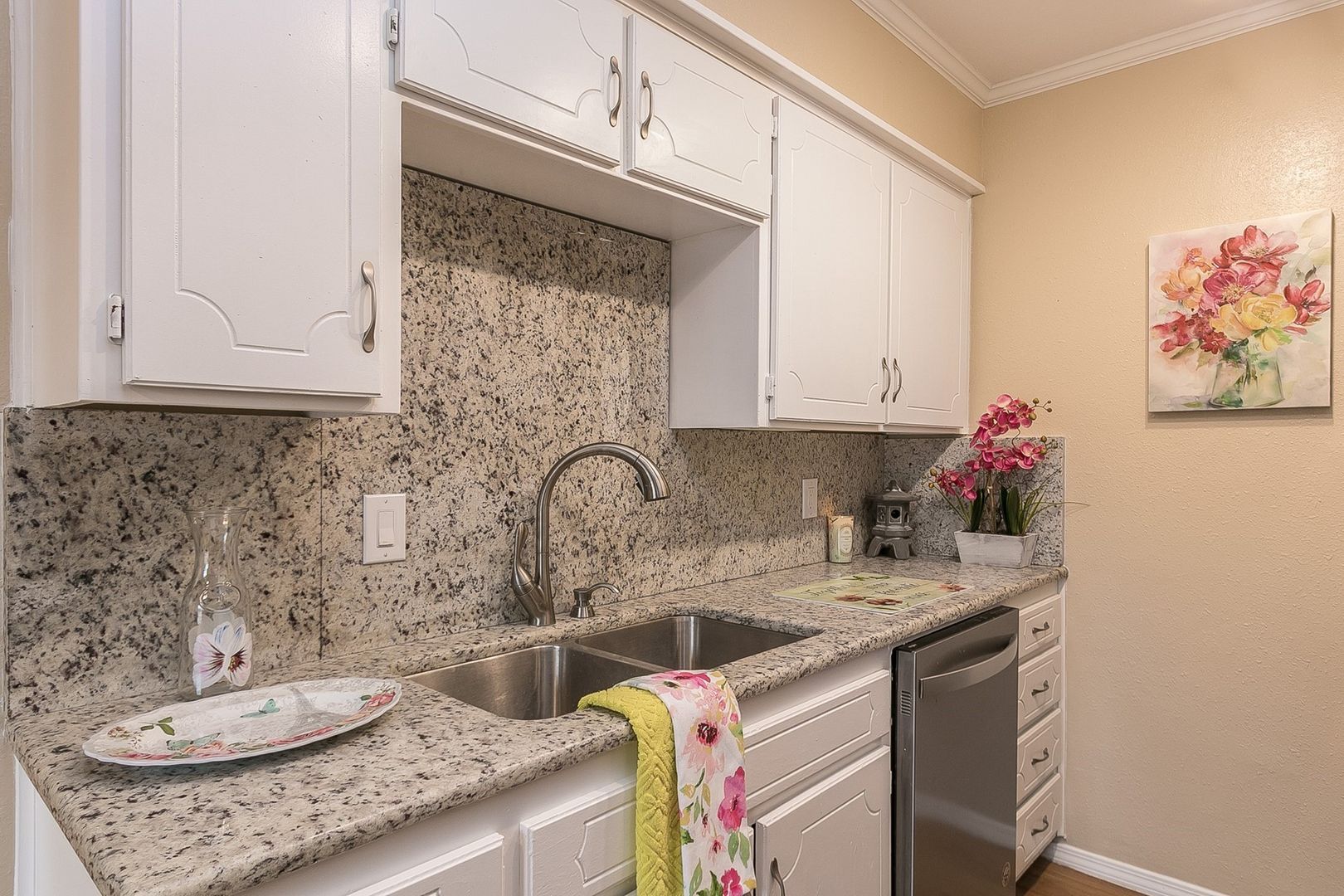 Kitchen image with white cabinetry and stone countertop and backsplash