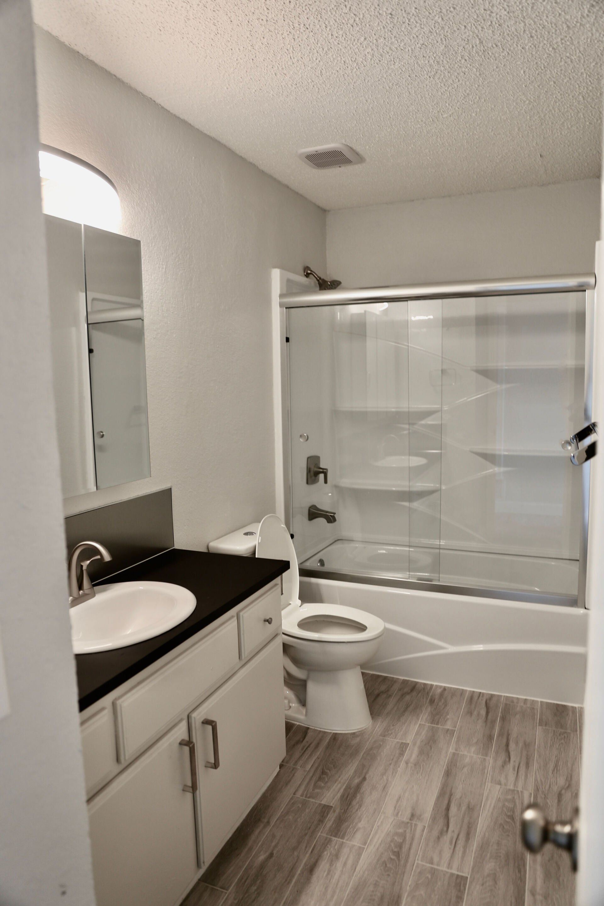 A bathroom with a toilet , sink , and shower.