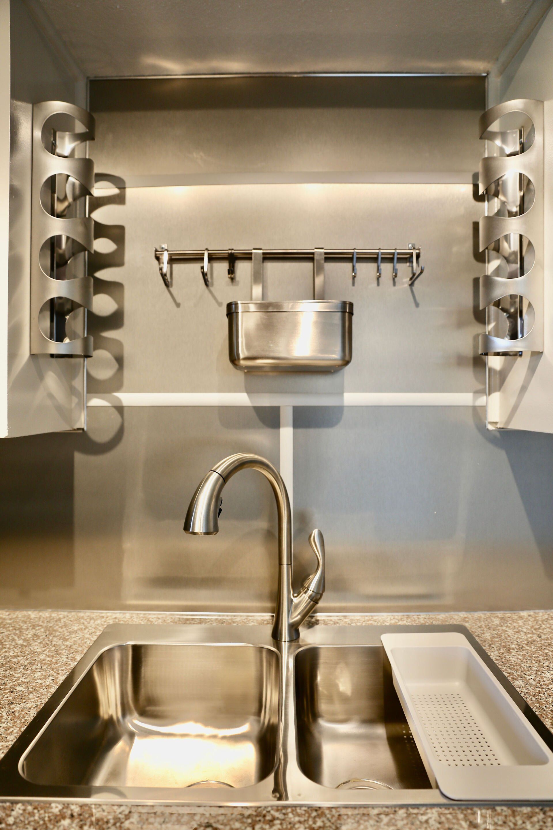 Luxury Upgraded unit kitchen with a stainless steel sink and faucet, stainless steel wine racks and stainless steel utensil holder