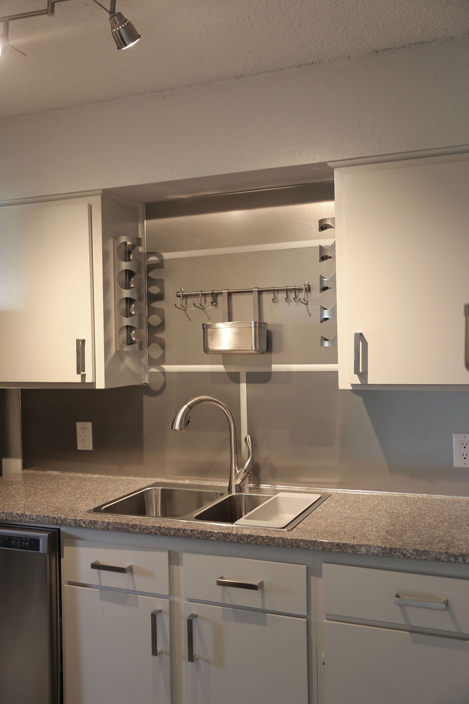 Luxury upgraded kitchen with white cabinets and a stainless steel sink & faucet and backsplash, granite countertop