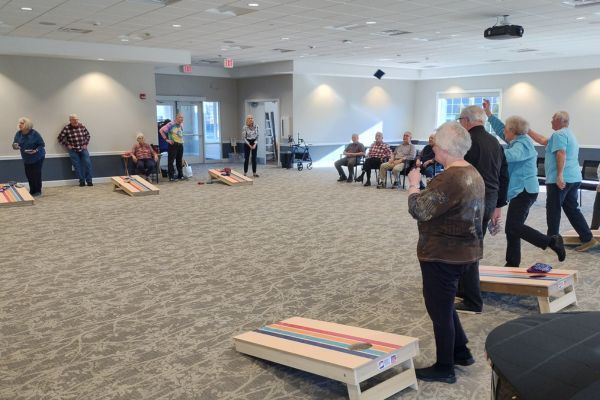 Residents playing bean bag toss at Peterson Meadows