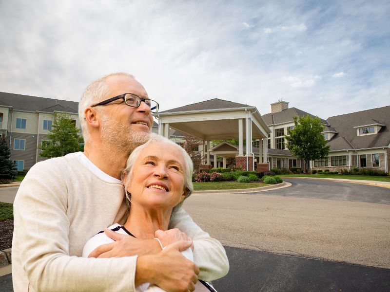 Couple standing in front of the community center at an independent senior living community