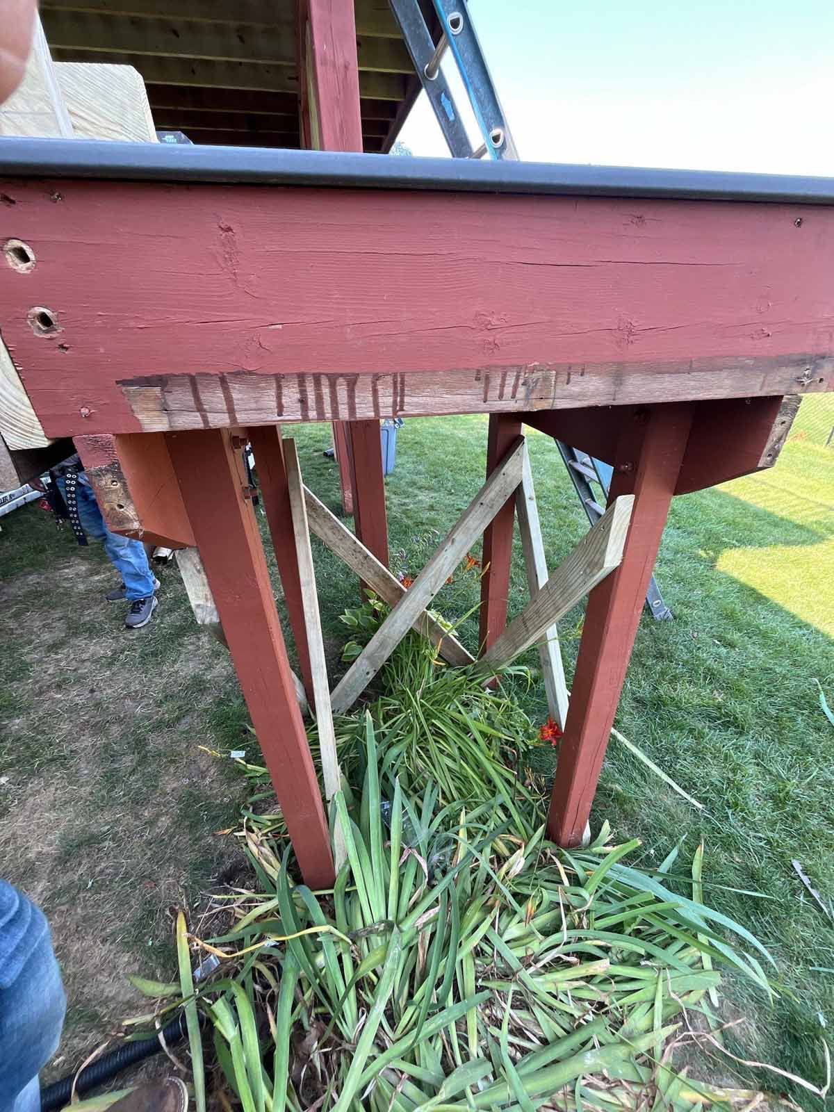 Red deck with angled support beams over grass.