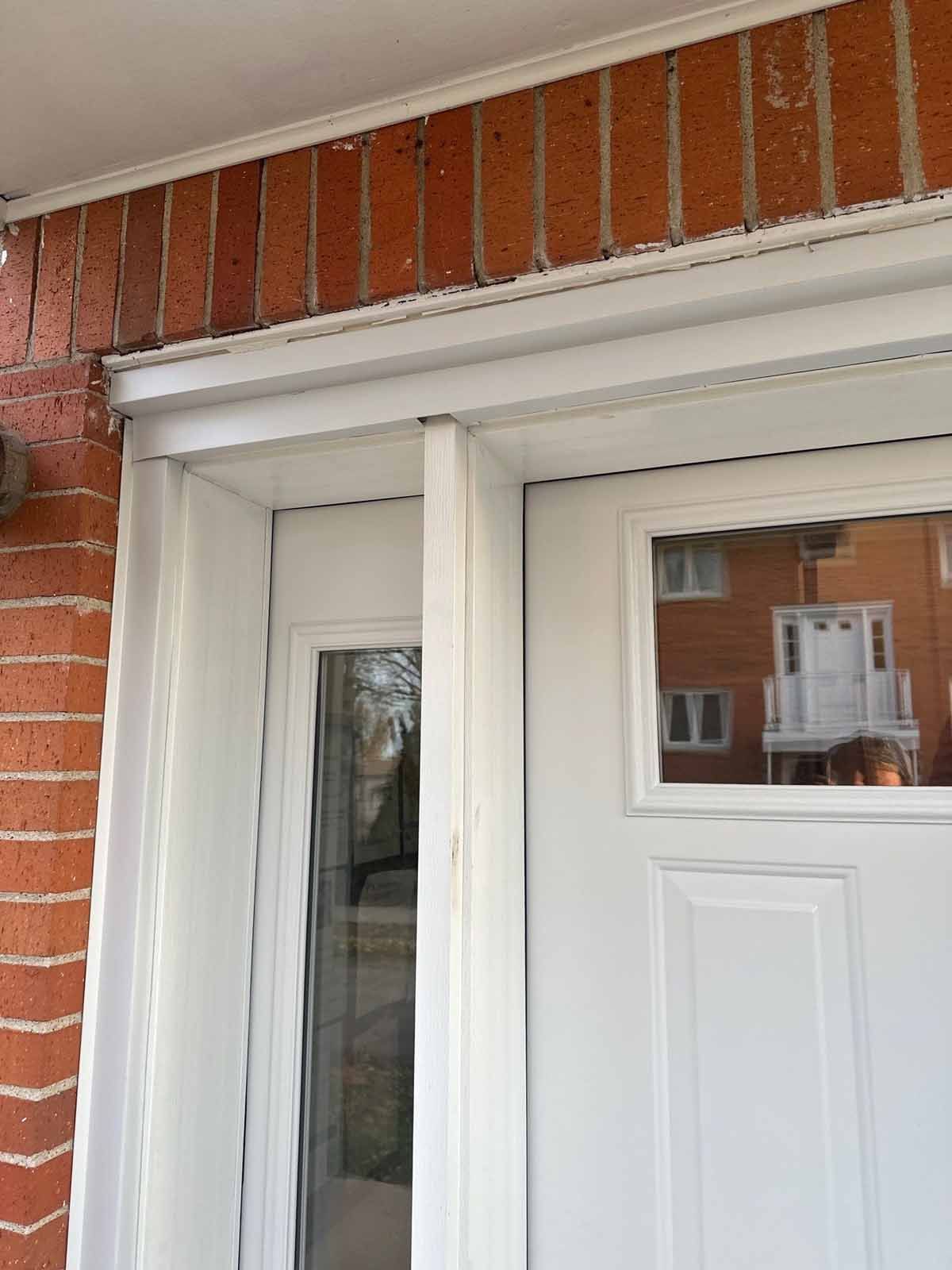 White door with glass and a brick exterior with white trim.