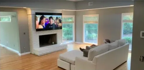 White sectional sofa in a living room with gray walls and built-in white shelving.