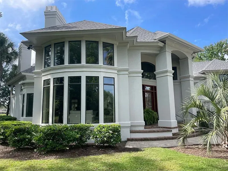 White sectional sofa in a living room with gray walls and built-in white shelving.