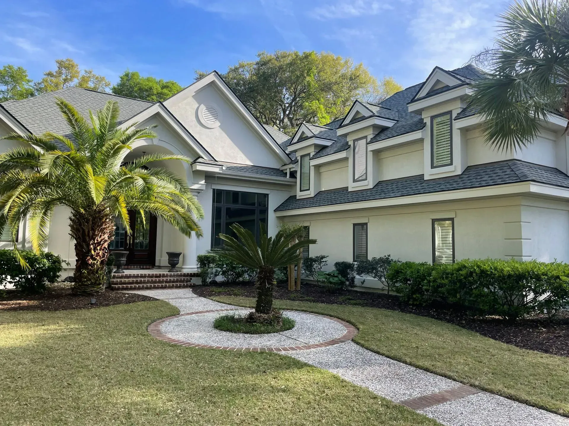 White sectional sofa in a living room with gray walls and built-in white shelving.