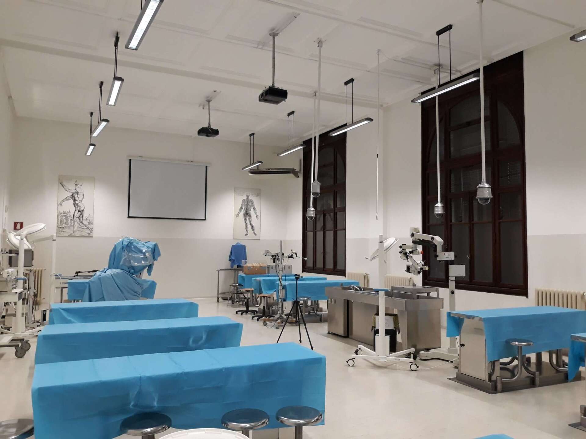 An empty classroom with blue tables and stools