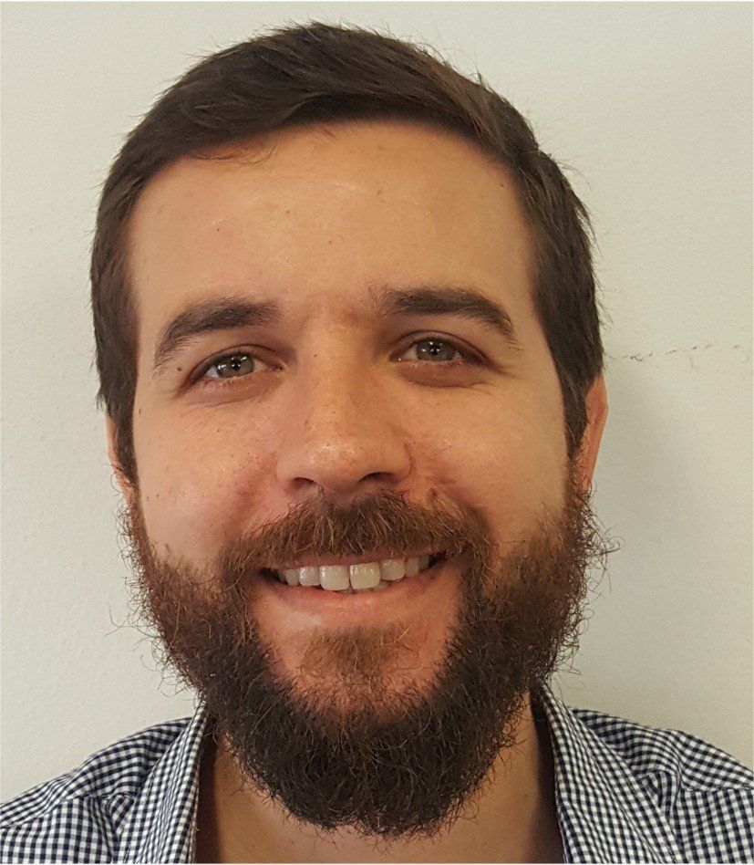 A man with a beard is smiling for the camera.