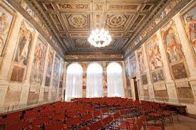 A large room filled with red chairs and a chandelier.