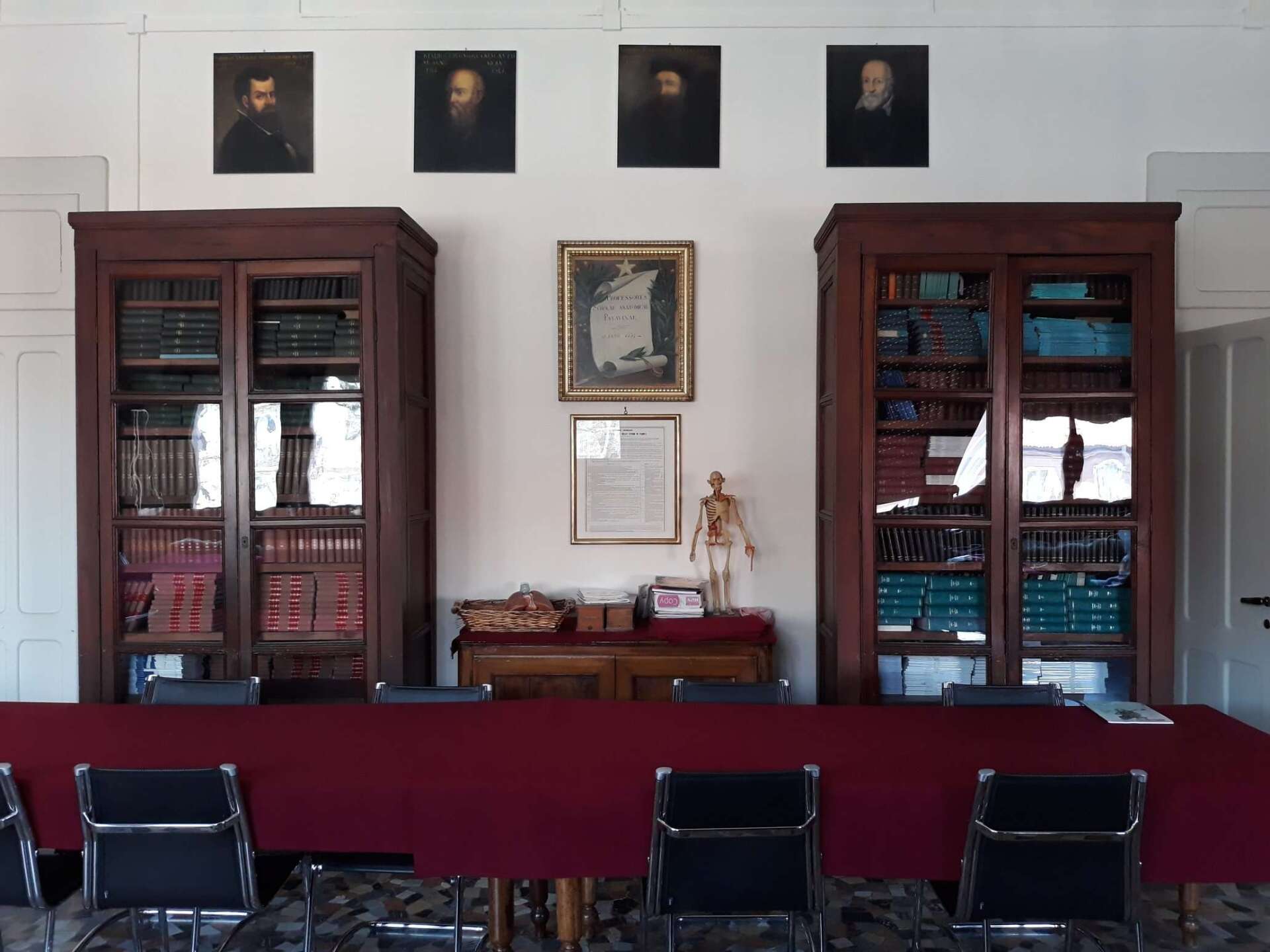 A room with a long red table and chairs