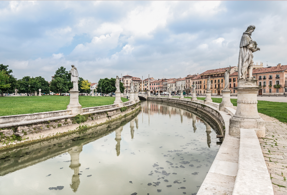 A river with statues on the side of it and buildings in the background.