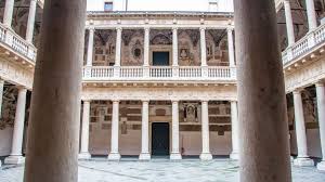 A large building with columns and balconies in a courtyard.