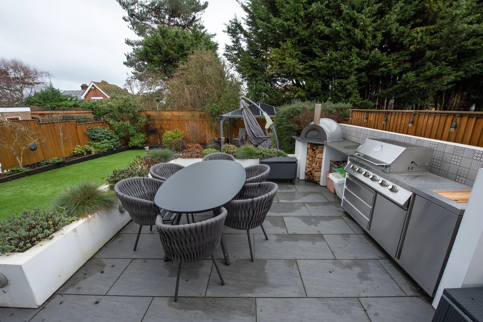 A patio with a table and chairs and a grill