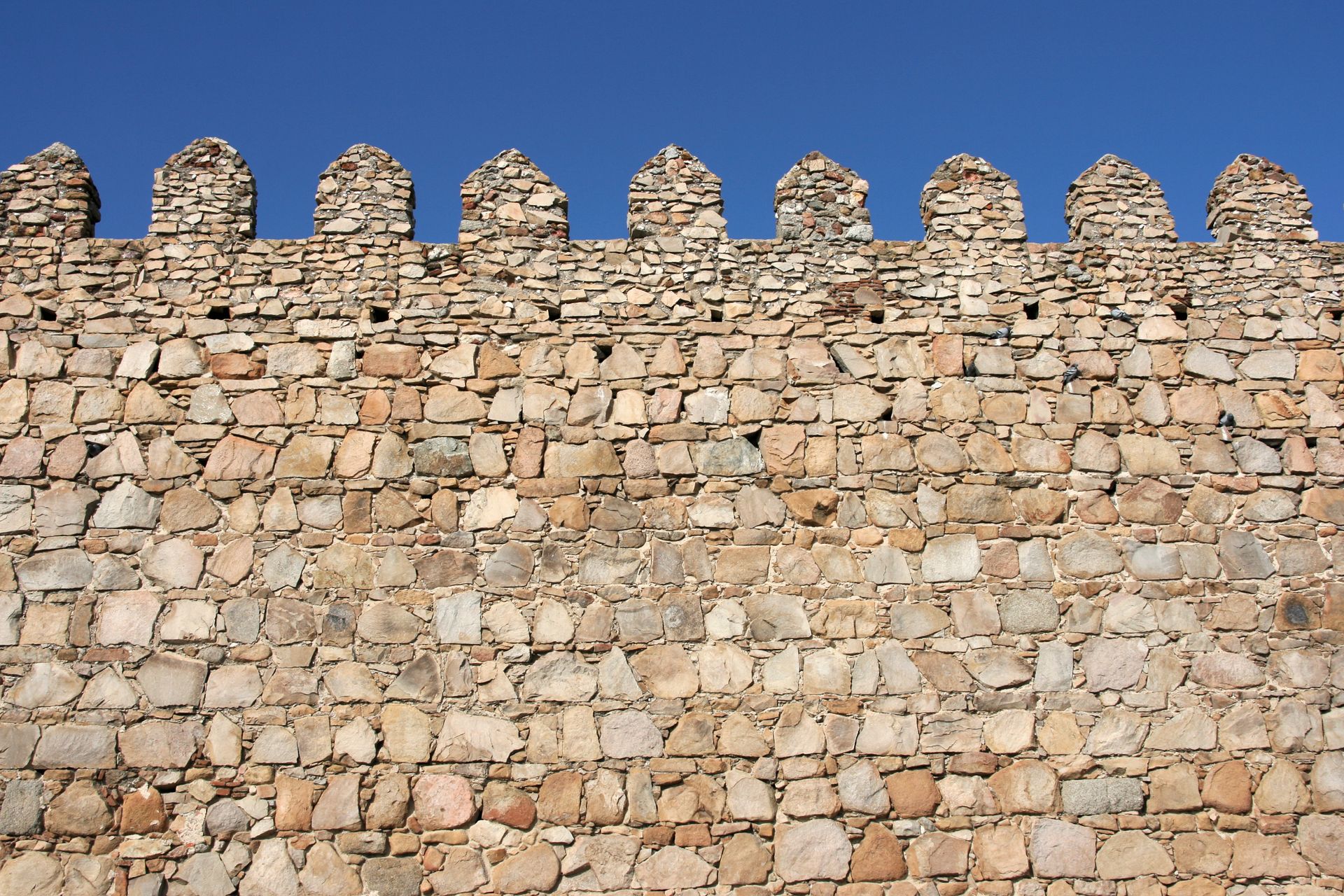 A stone wall with a blue sky in the background