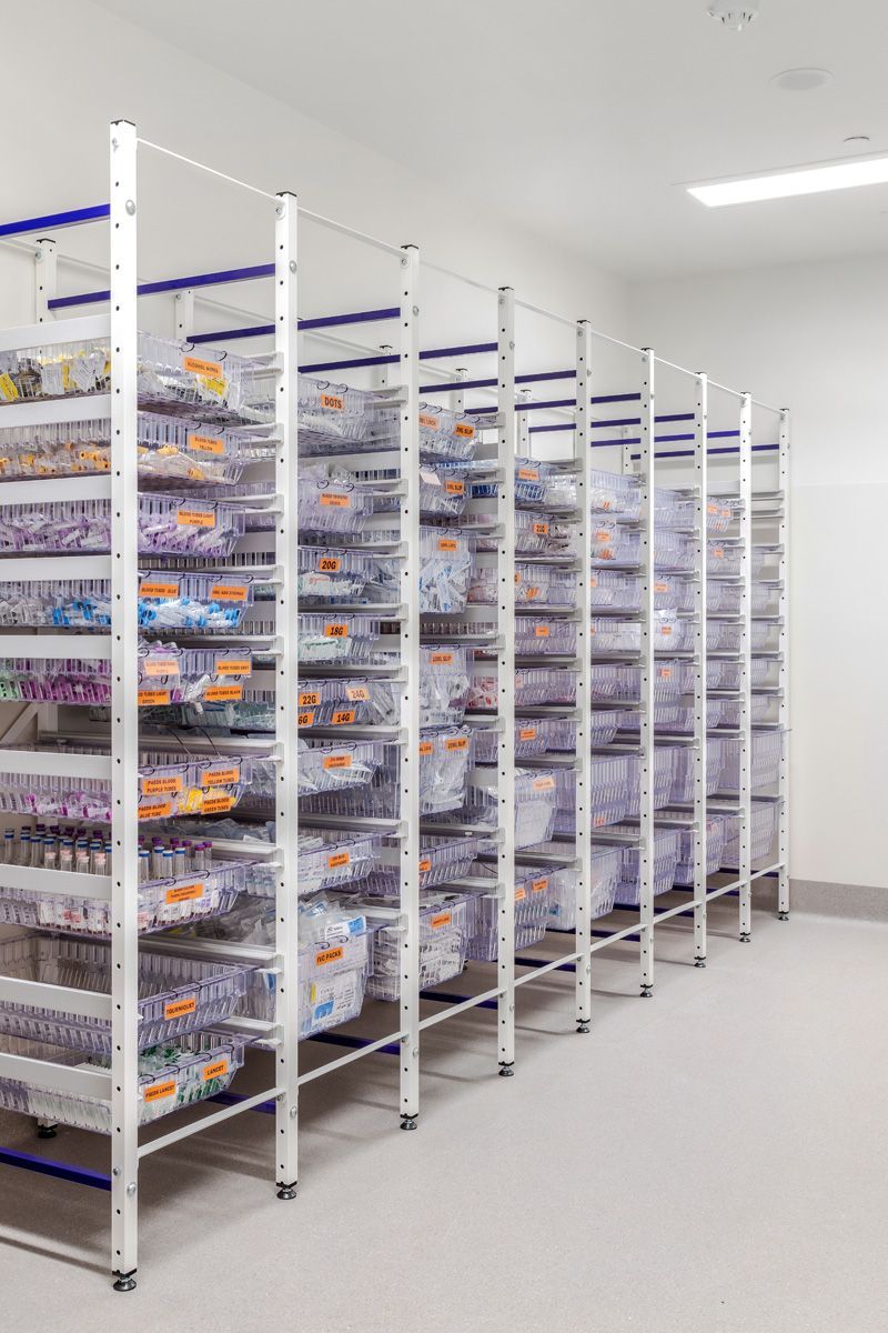 A row of shelves filled with plastic containers in a room.