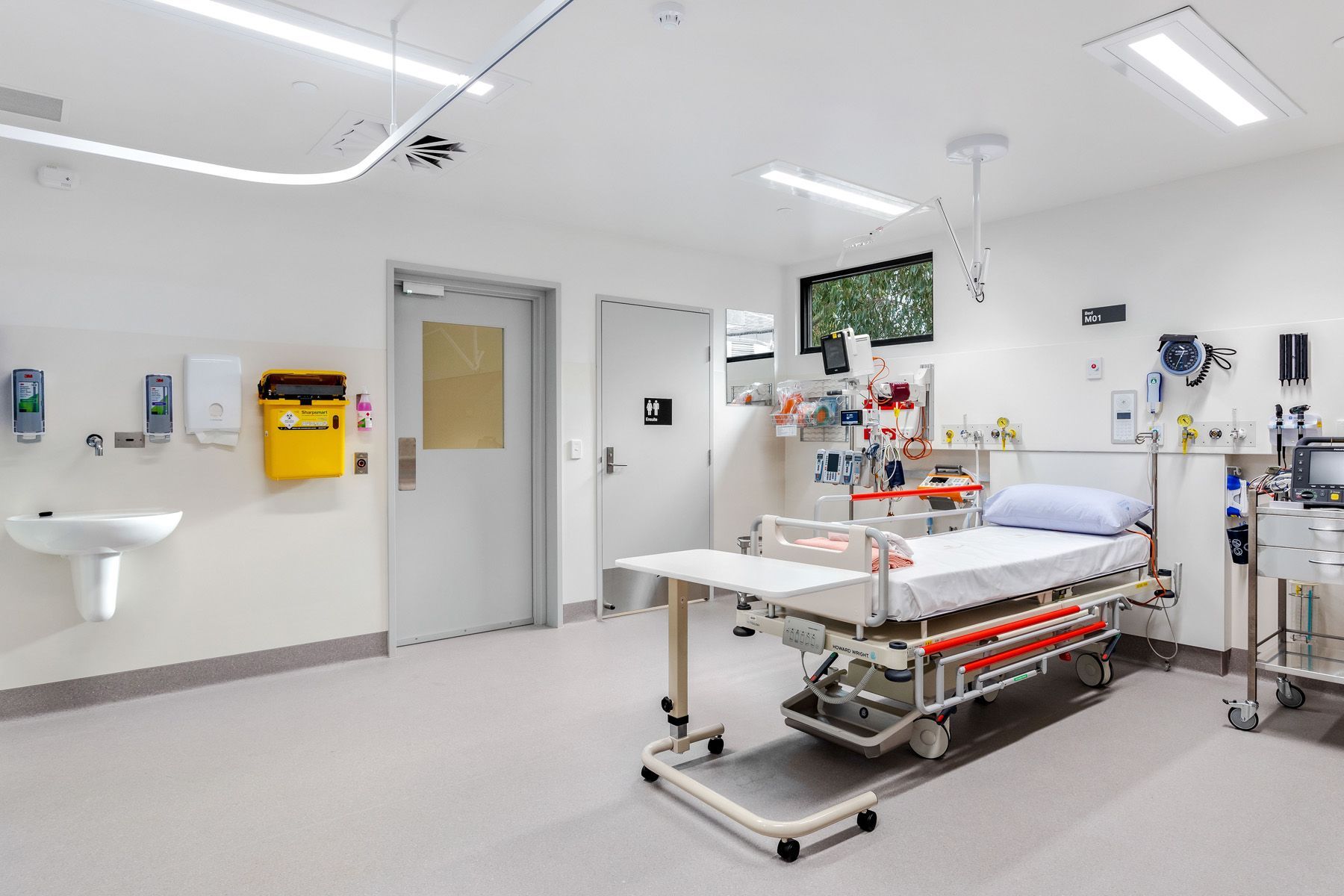 A hospital room with a bed and a sink.