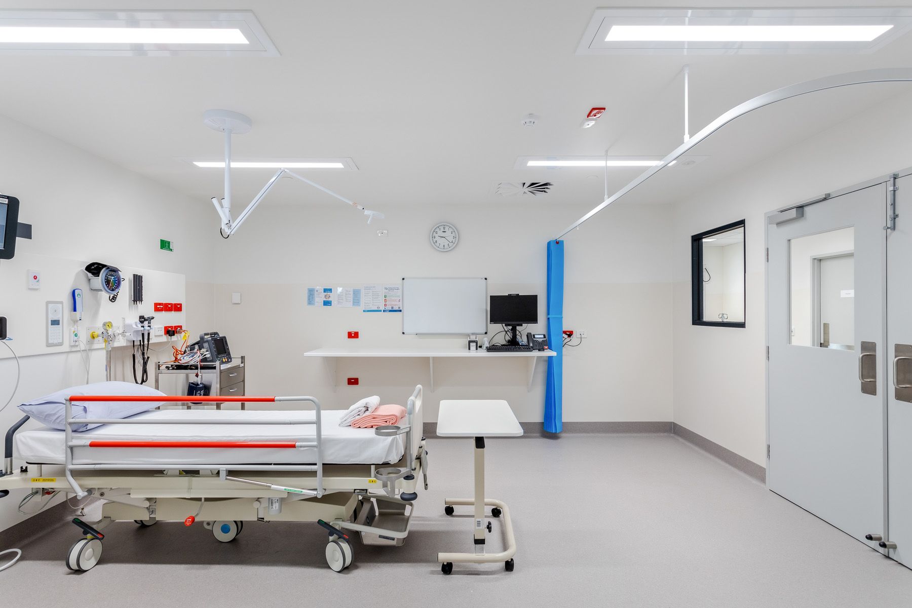 A hospital room with two beds and a table.