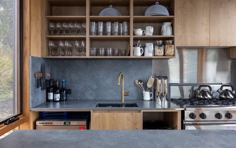 A kitchen with stainless steel appliances , wooden cabinets , a sink , and a stove.